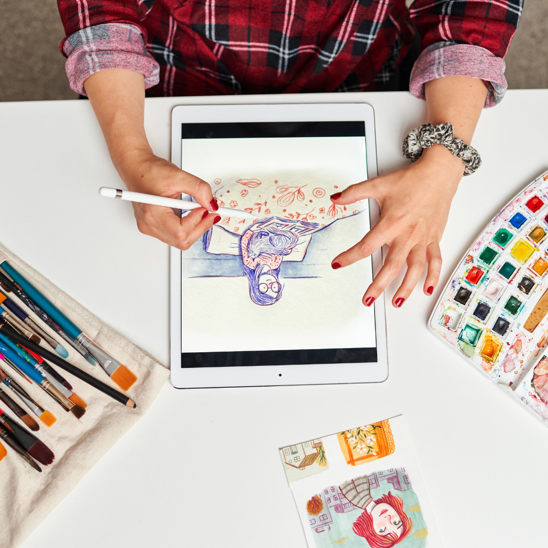 Illustratrice au travail sur sa tablette graphique dans son atelier de création